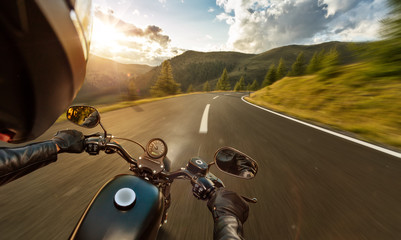 Naklejka premium POV motorbiker trzymając kierownicę, jazda w Alpach