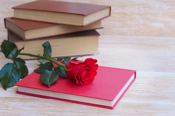 Old book and red rose, traditional gift for Sant Jordi, the Saint Georges Day. It is Catalunya's...
