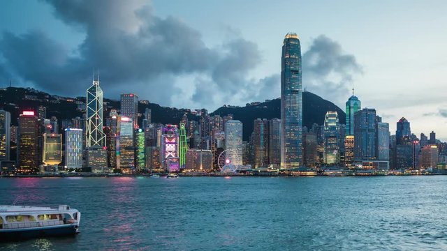 Hong Kong, China, day to night time lapse view of skyline and Victoria Harbour, dolly left to right. 