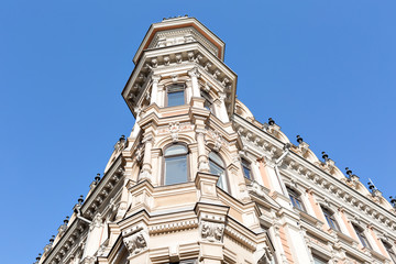 Fototapeta premium Beautiful old house in centre of Helsinki, Finland. Blue cloudy sky in background with sun. Helsinki, Finland, Scandinavia, Europe.