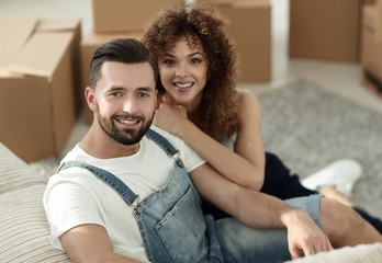Obraz premium Young couple sitting on the floor in a new apartment
