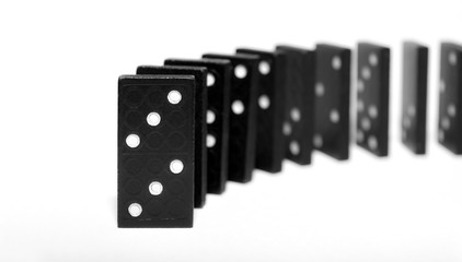 Curved row of black wooden dominoes standing on a white background. Logical Game. Business concept....