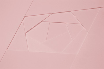 Abstract geometric background in light pastel tones from sheets of thick pale pink paper, cardboard.