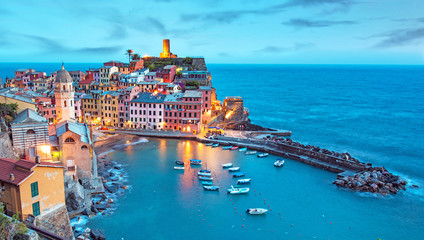 Magical landscape with boats in the bay and colored houses on the rock in Vernazza, Cinque Terre, Italy, Europe at night
