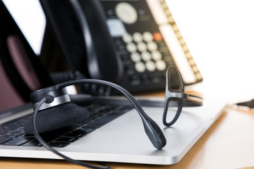 Headset on computer laptop at Call center support table