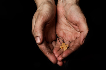 Wooden handmade cross in the palm of a peasant woman.