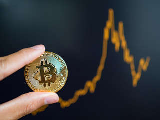 Golden bitcoin coin on background of technical graph.