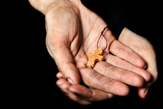Wooden handmade cross in the palm of a peasant woman.