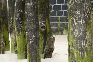 port wooden pillars in sand on the beach