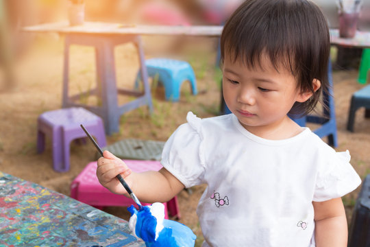 Asian cute girl baby is painting colorful.