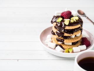 A sweet dessert of a chocolate cookie raspberry and marshmallow Cup of coffee on a light table.