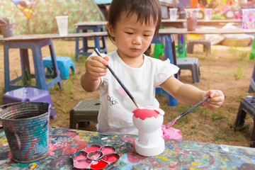 Asian cute girl baby is painting colorful.