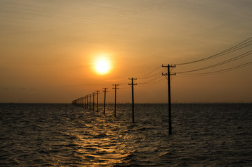 Sunset Over Utility Poles in a Sea