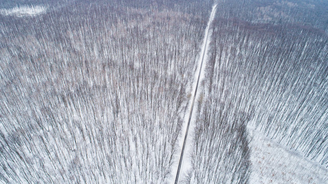 Fototapeta Aerial drone view of road in idyllic winter landscape