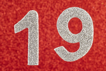 Number nineteen silver color over a red background. Anniversary.