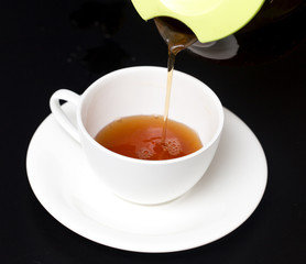 Tea in a cup on a black background