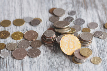 Different collector coins and gold bitcoin on the wooden background