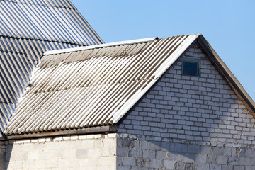 Snow on the roof of the house in winter