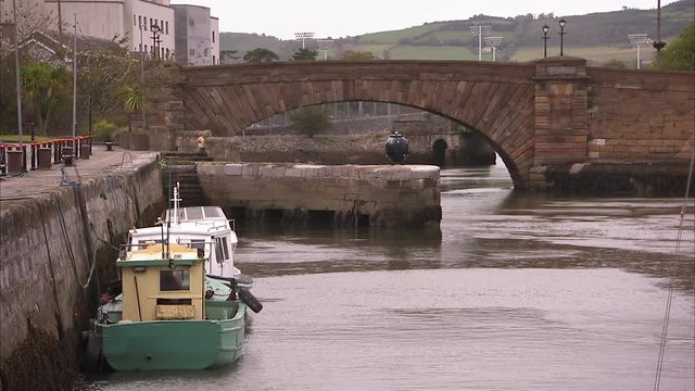 Shot of an old Irish canal made of stone, with boats anchored to the side.