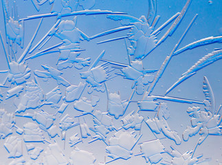 Blue drawings on the glass in the frost