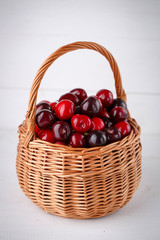 Cherries in basket on wooden background