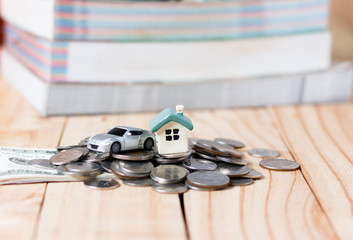 The house and a car on the pile of money in the concept of money to buy a home and a car