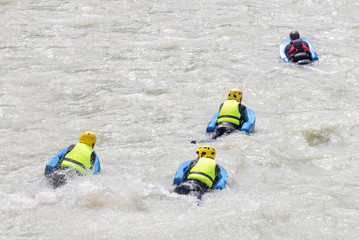 Fototapeta na wymiar Group of people on river bugs in white water, active vacations, team concept