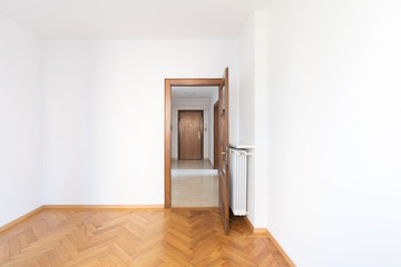 Empty room in a apartment with white walls and wooden floors