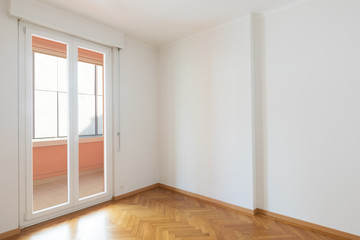 Empty room in a apartment with white walls and wooden floors