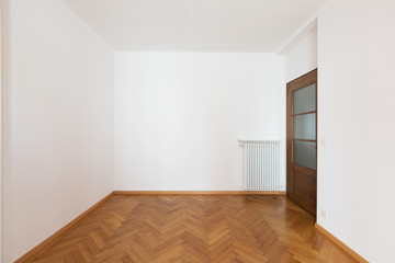 Empty room in a apartment with white walls and wooden floors