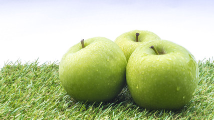 Closeup of green apple with water drops on white background. Selective focus.
