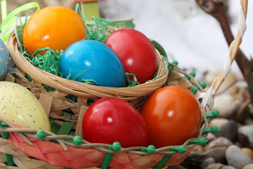 körbchen mit bunten ostereiern im garten mit schnee