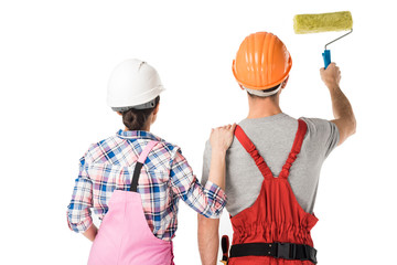 Rear view of male and female builders working with paint roller isolated on white
