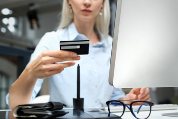 Zakupy on line.
Kobieta używa z karty kredytowej do zapłaty w komputerze.
