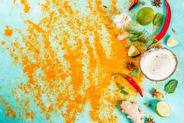 Asian and thai food, cooking background. Spices and ingredients - coconut, ginger, hot red peppers, lime, curry, mint, spices. Light blue background. Top view copy space