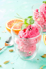 Ice cream, blood orange and cardamom sorbet, with fresh oranges and mint,  light blue background,...
