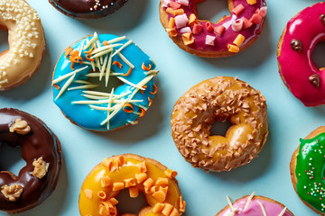 Various donuts on blue background, from above