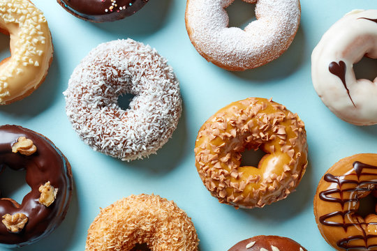 Various donuts on blue background, from above