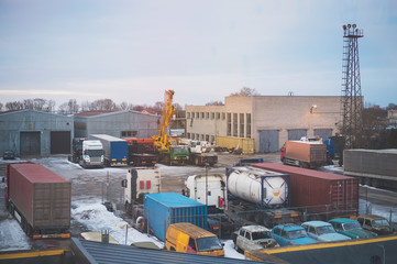 Industrial backyard with trailers, crane and trucks.