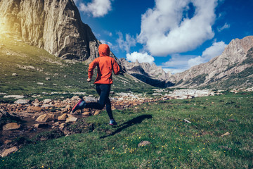woman trail runner running on beautiful mountains