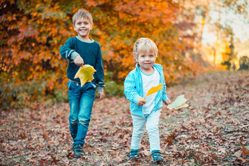 Two smiling kids in autumn park