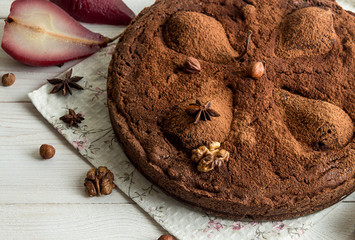 Chocolate cacke with pears stewed in red wine, hazelnuts, walnuts. Traditional dessert.