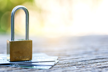 The padlock on a credit card lie on wooden table is Protection of credit Visa against hacker...