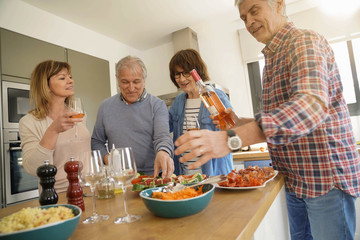 Group of senior friends preparing lunch meal together