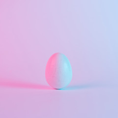 White Easter egg with colorful ultraviolet holographic neon lights. Creative concept.