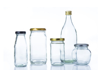 Clear glass bottles in various sizes and shapes with lids on white background