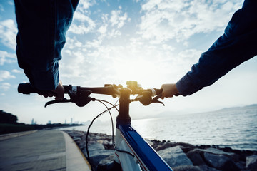 cyclist riding bike in the sunrise coast path