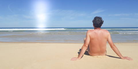 back view single man nudist on sea beach summer vacation