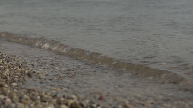 small water waves on the stoney beach in slow motion