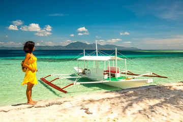Young woman with yellow dress standing and watching the beautifu